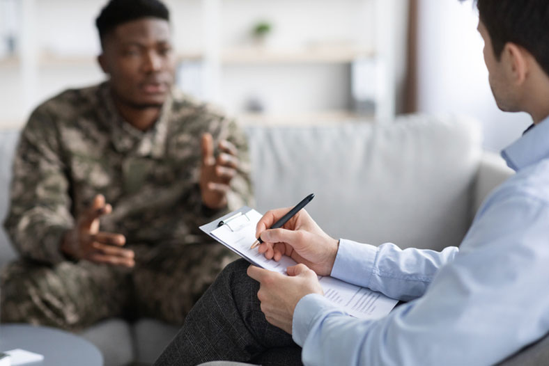 social worker taking notes while talking to military man