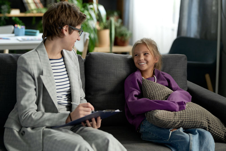 social worker with girl on sofa