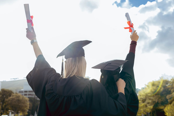 graduates celebrating with diplomas in hand